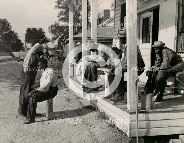 Haircutting in Front of General Store and Post Office on Marcella Plantation, Mileston, M..., 1939. Creator: Marion Post Wolcott.