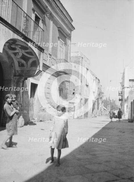 Street scene in an unknown country, possibly in Central America or Spain, between 1911 and 1942. Creator: Arnold Genthe.
