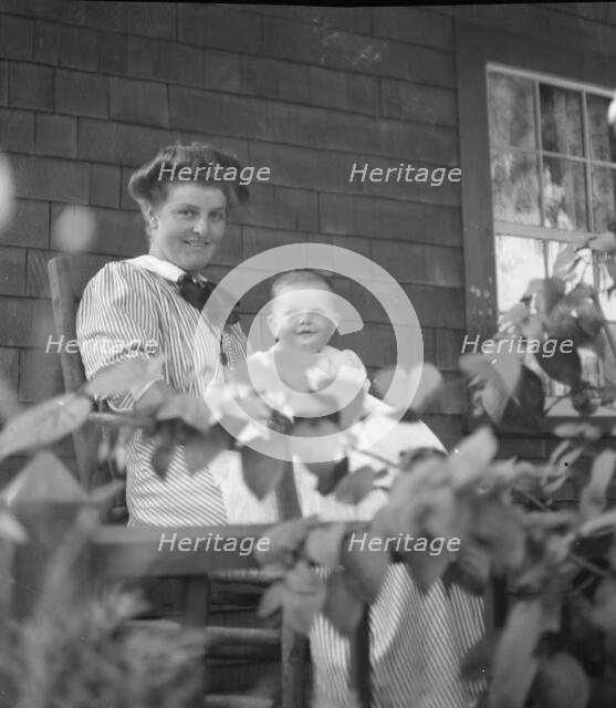 Unidentified woman and baby, seated on porch, between 1911 and 1942. Creator: Arnold Genthe.