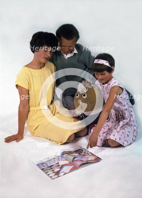 Family group looking at a magazine, 1963. Artist: Michael Walters