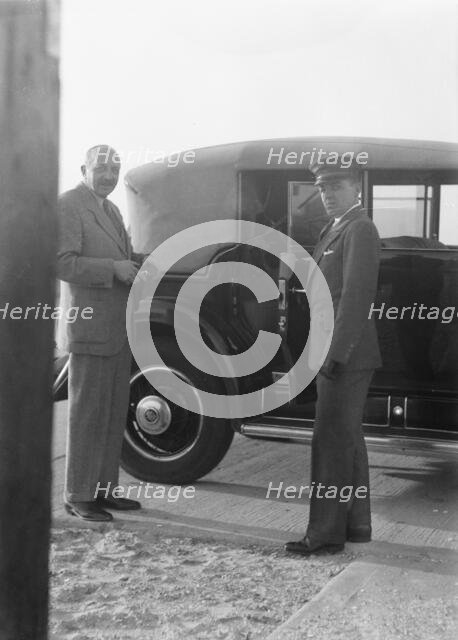 Rothbart, Albert, Mr., standing by his car with his chauffeur, between 1920 and 1935. Creator: Arnold Genthe.