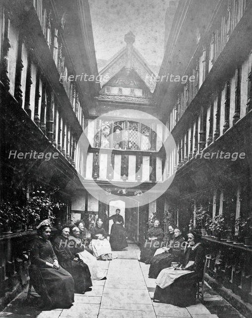 Ford's Hospital, Coventry: residents seated in the courtyard looking toward the street, c1880s. Creator: Unknown.