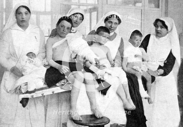 Wounded children from Ypres with nurses at La Panne, Belgium, First World War, 1914-1918, (c1920). Artist: Unknown