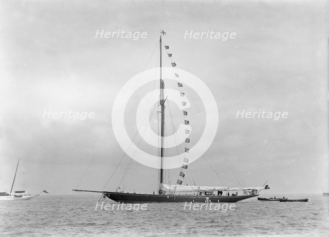 The 221 ton cutter 'Britannia' at anchor with prize flags, 1921. Creator: Kirk & Sons of Cowes.