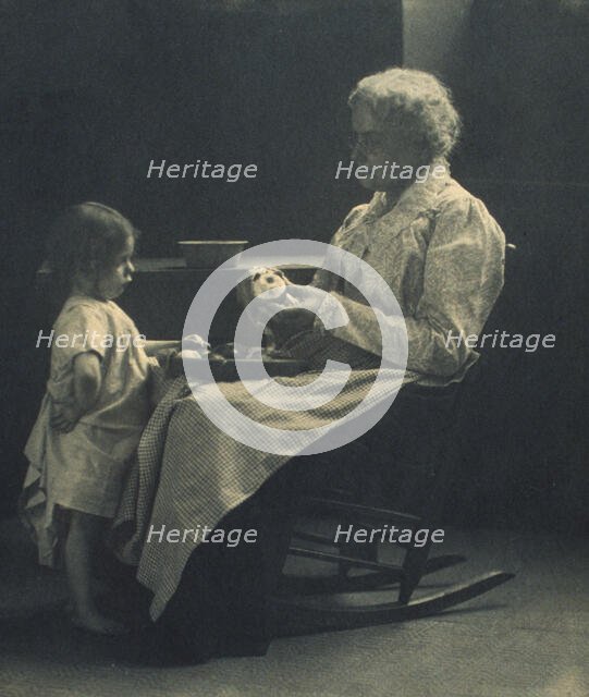Elderly woman in a rocking chair peeling apple with young girl standing in front of her, c1900. Creator: Elizabeth B. Brownell.