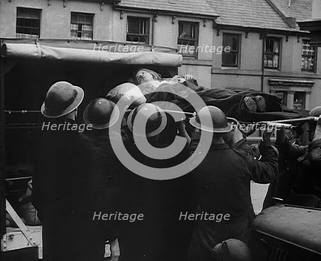 An Injured Child Being Carried Into an Ambulance, 1940. Creator: British Pathe Ltd.