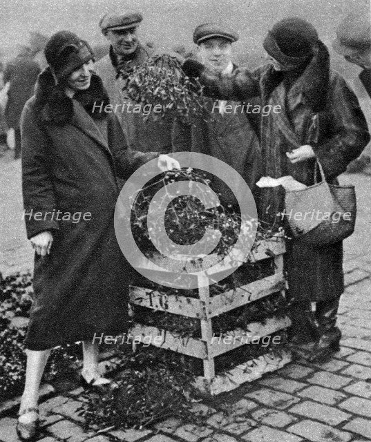 Women choosing bunches of mistletoe, Caledonian Market, London, 1926-1927. Artist: Unknown