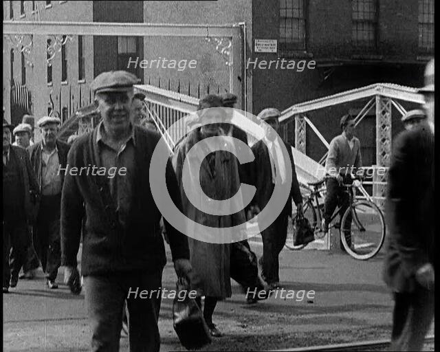 Workers Leaving Factory Through Factory Gates Which Are Closed After Them, 1932. Creator: British Pathe Ltd.