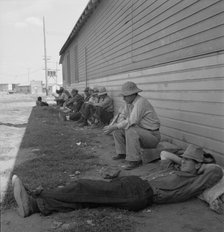 Idle men seated in shade on the other side of..., Tulelake, Siskiyou County, California, 1939. Creator: Dorothea Lange.