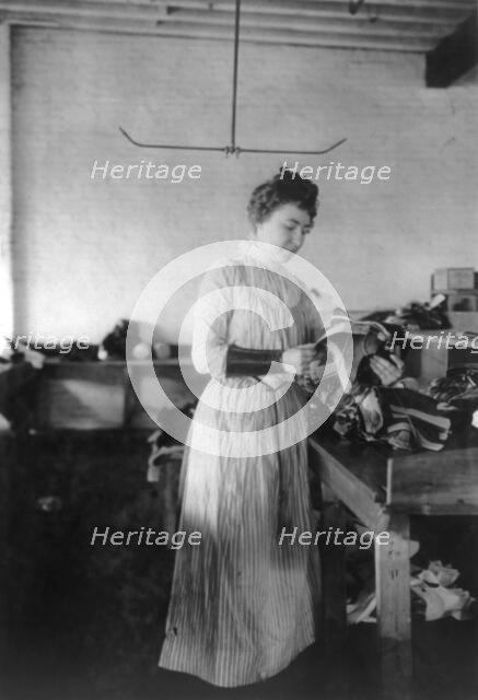 Woman distributing work in a shoe factory, Lynn, Mass., (1895?). Creator: Frances Benjamin Johnston.