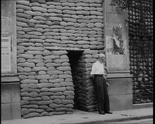 A Man Standing Outside the Frontage of a Building Obscured By Sandbags Next To an..., 1937. Creator: British Pathe Ltd.