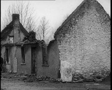 A Man Standing Outside a Burnt Out Cottage in Ireland, Holding a Bicycle, 1921. Creator: British Pathe Ltd.