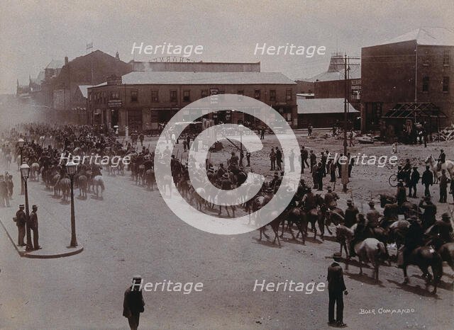 South Africa: Boer soldiers riding through a street in a South African town, 1896. Creator: Barnett.