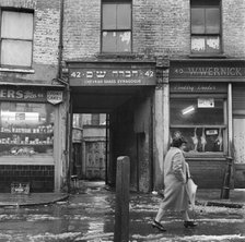 A woman walks past the Chevrah Shass Synagogue, Whitechapel, London c1946-c1959. Artist: John Gay