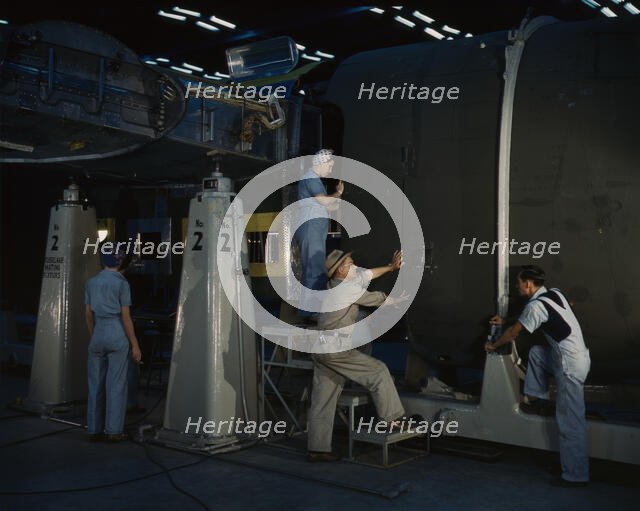 Putting the nose section of a mighty transport...Consolidated Aircraft..., Fort Worth, Texas, 1942. Creator: Howard Hollem.