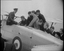 An RAF Officer Showing a Group of Male Children His Aeroplane, 1931. Creator: British Pathe Ltd.