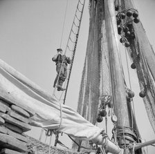 Gloucester fisherman standing in the rigging of a New England fishing boat, New York, 1943. Creator: Gordon Parks.