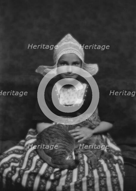 Silvester child with Buzzer the cat, portrait photograph, 1913 Mar. 3. Creator: Arnold Genthe.