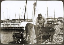 A fisherman and his wife with nets and a wheelbarrow, Borstahusen, Landskrona, Sweden, 1905. Artist: Unknown