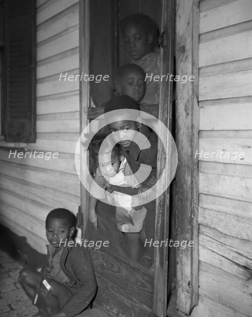 Negro children in the front door of their home, Washington (southwest section), D.C., 1942. Creator: Gordon Parks.