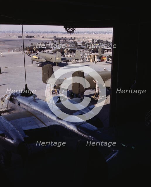 Another North American B-25 bomber rolls off the final assembly line to join other ships..., 1942. Creator: Alfred T Palmer.