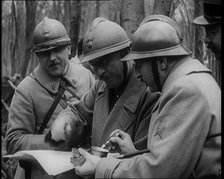 Three Male French Soldiers Standing in a Wood Looking at a Map, 1924. Creator: British Pathe Ltd.