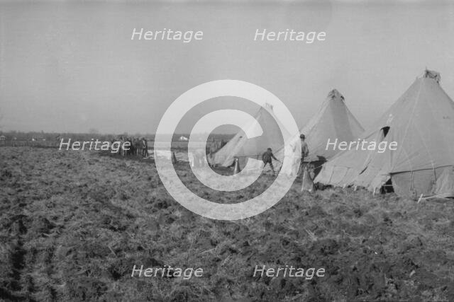 Possibly: Setting up a tent in the camp for white flood refugees, Forrest City, Arkansas, 1937. Creator: Walker Evans.
