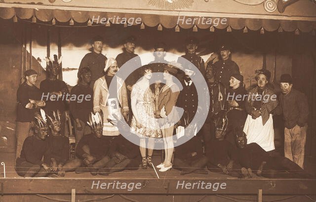 Soldiers, some in drag, pose on stage; two men in drag face each other in the centre, [1910-1919?]. Creator: Unknown.