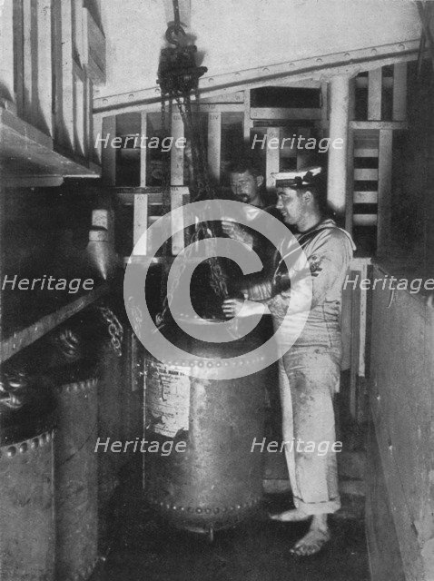 'Taking a submarine mine out of stores', 1914. Artist: Unknown.