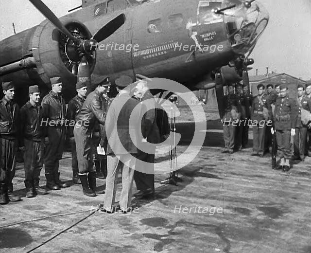 Two Male Officers Talking to a Group of Pilots in front of a Bomber Aircraft, 1943-1944. Creator: British Pathe Ltd.