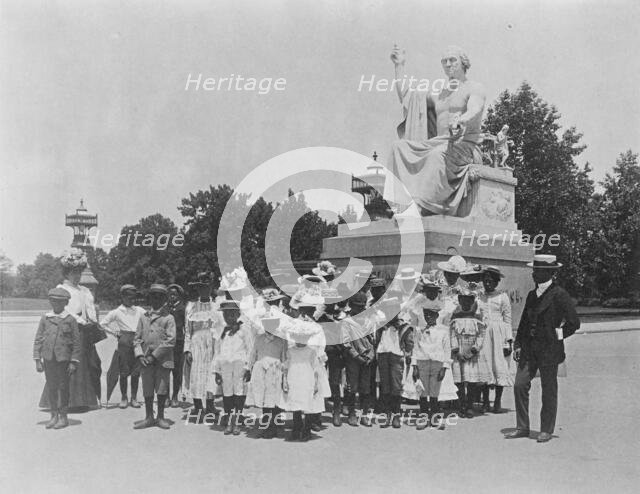 Group of school children in front of statue of George Washington, Washington, D.C., (1899?). Creator: Frances Benjamin Johnston.