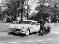 An Oldsmobile at the corner of an American street, 1954. Artist: Unknown