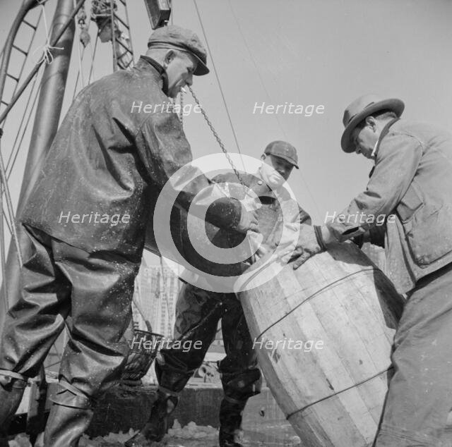 Filling a barrel with codfish at the Fulton fish market, New York, 1943. Creator: Gordon Parks.