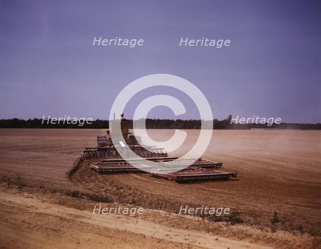 Harrowing a field with a diesel tractor, Seabrook Farm, Bridgeton, N.J., 1942. Creators: Marion Post Wolcott, John Collier.