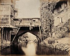 Kashmir: a built-over bridge on a canal betweeen houses, c1870s. Creator: Samuel Bourne.