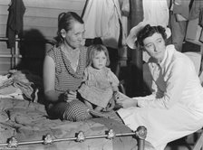 Nurse attending sick baby, FSA camp, Farmersville, Tulare County, California, 1939. Creator: Dorothea Lange.