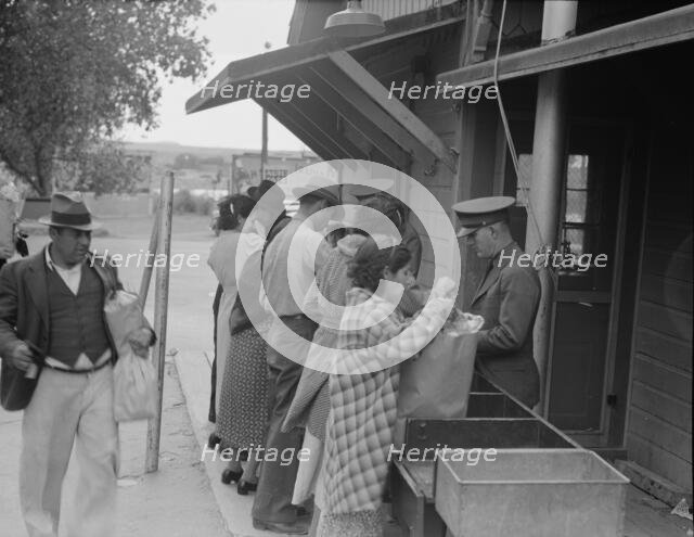 Plant quarantine inspectors examining packages brought over the bridge..., Texas, 1937. Creator: Dorothea Lange.