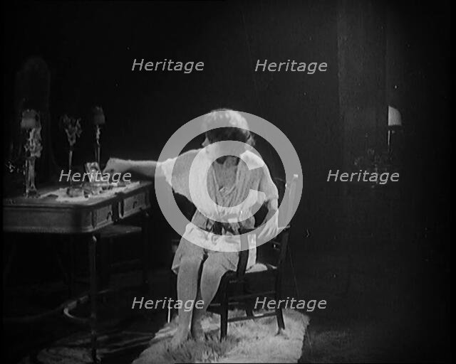 Female Civilian Dressing in Undergarments Seating in Front of a Dressing Table, 1920. Creator: British Pathe Ltd.