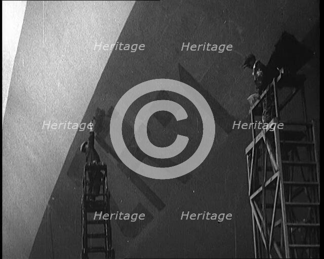 An R 38 Airship Body Being Painted in a Hangar, 1921. Creator: British Pathe Ltd.
