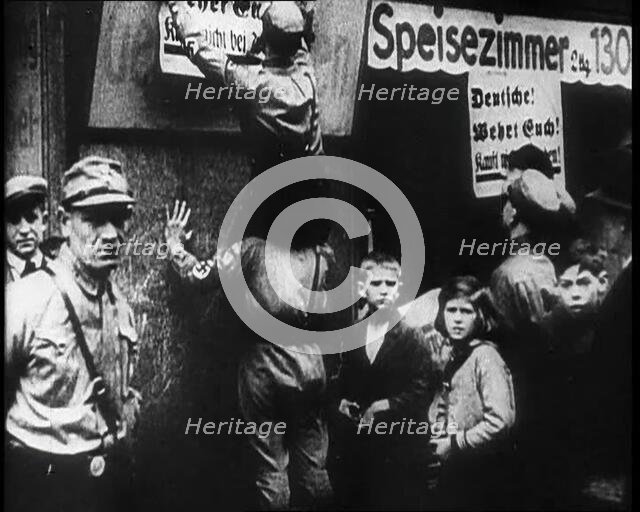 Men in Nazi Uniforms attaching anti-Jewish Posters, 1933. Creator: British Pathe Ltd.