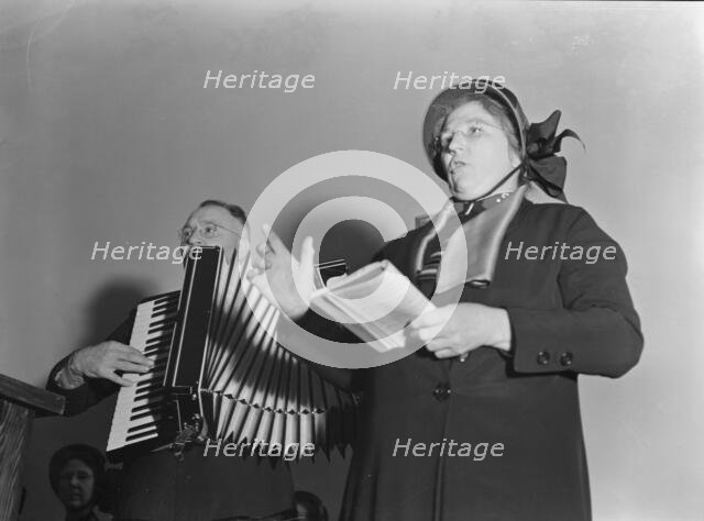 Adjutant and his wife sing, Salvation Army, San Francisco, California, 1939. Creator: Dorothea Lange.
