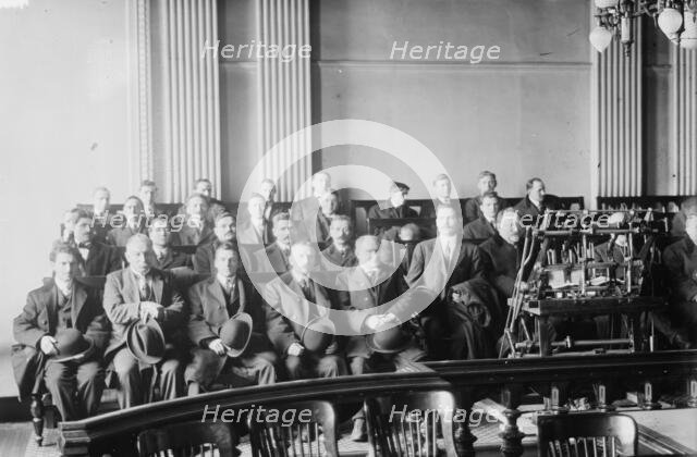 Candidates for naturalization seated in room, hats in laps, 1916. Creator: Bain News Service.