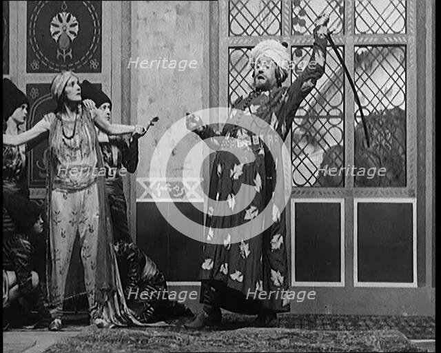 Scene from the Play 'Hassan': the Actor Henry Ainley in Full Costume Raising a Sword..., 1920s. Creator: British Pathe Ltd.