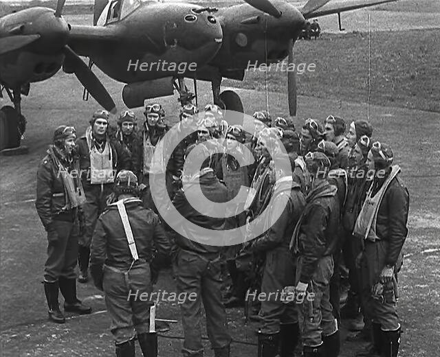 A Group of Male Pilots Talking in Front of an Aircraft, 1943-1944. Creator: British Pathe Ltd.