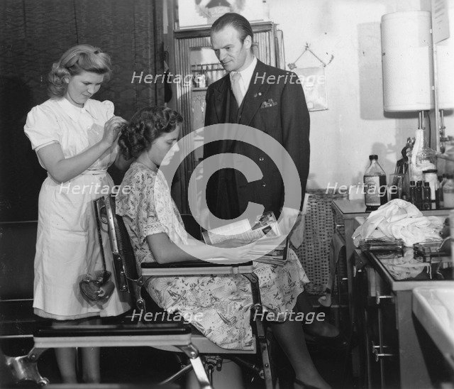 A girl passing the test to qualify as a hairdresser before a male inspector, Sweden, c1940-1959. Artist: Unknown