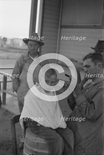 Community barber shop in Kern County migrant camp, California, 1936. Creator: Dorothea Lange.