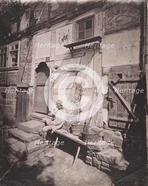 [Man Smoking Pipe Outside His Home on Village Street], 1880s. Creator: Unknown.