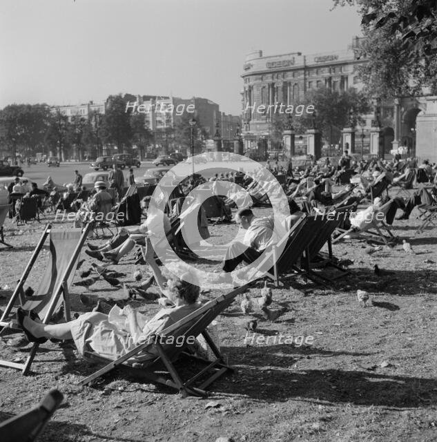 People relaxing on deck chairs amongst the pigeons in Hyde Park, London, 1960-1970. Creator: John Gay.