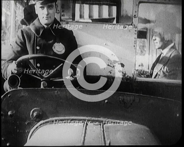 Male Bus Driver Sitting in the Cabin of a Bus, 1922. Creator: British Pathe Ltd.