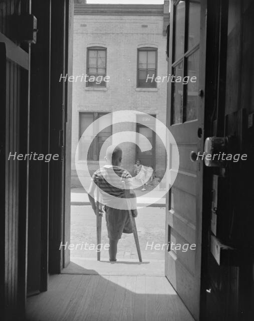 Young boy standing in the doorway of his home on Seaton Road...,Washington, D.C, 1942. Creator: Gordon Parks.
